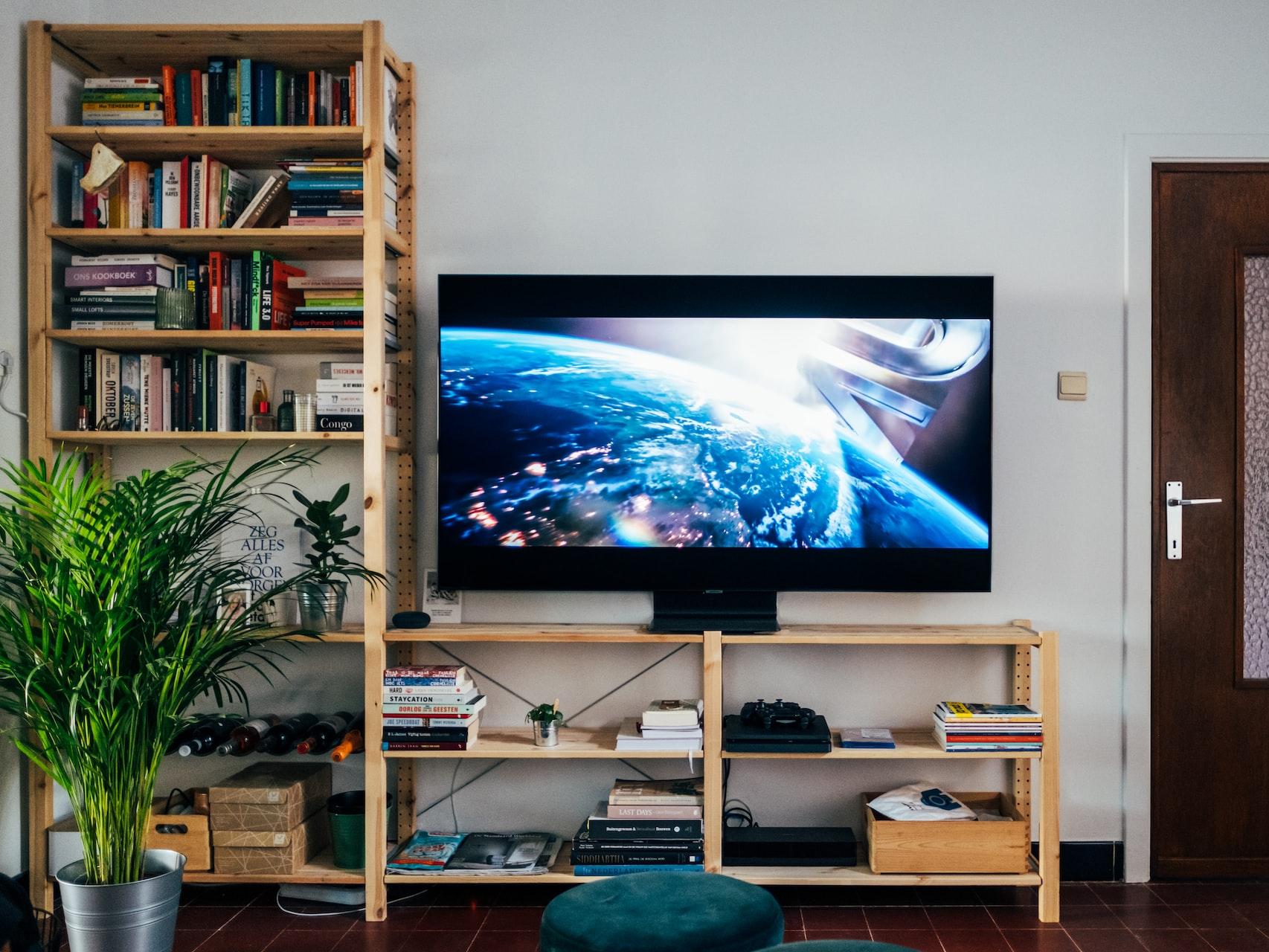 Un televisor de pantalla plana grande sobre un centro de entretenimiento de madera